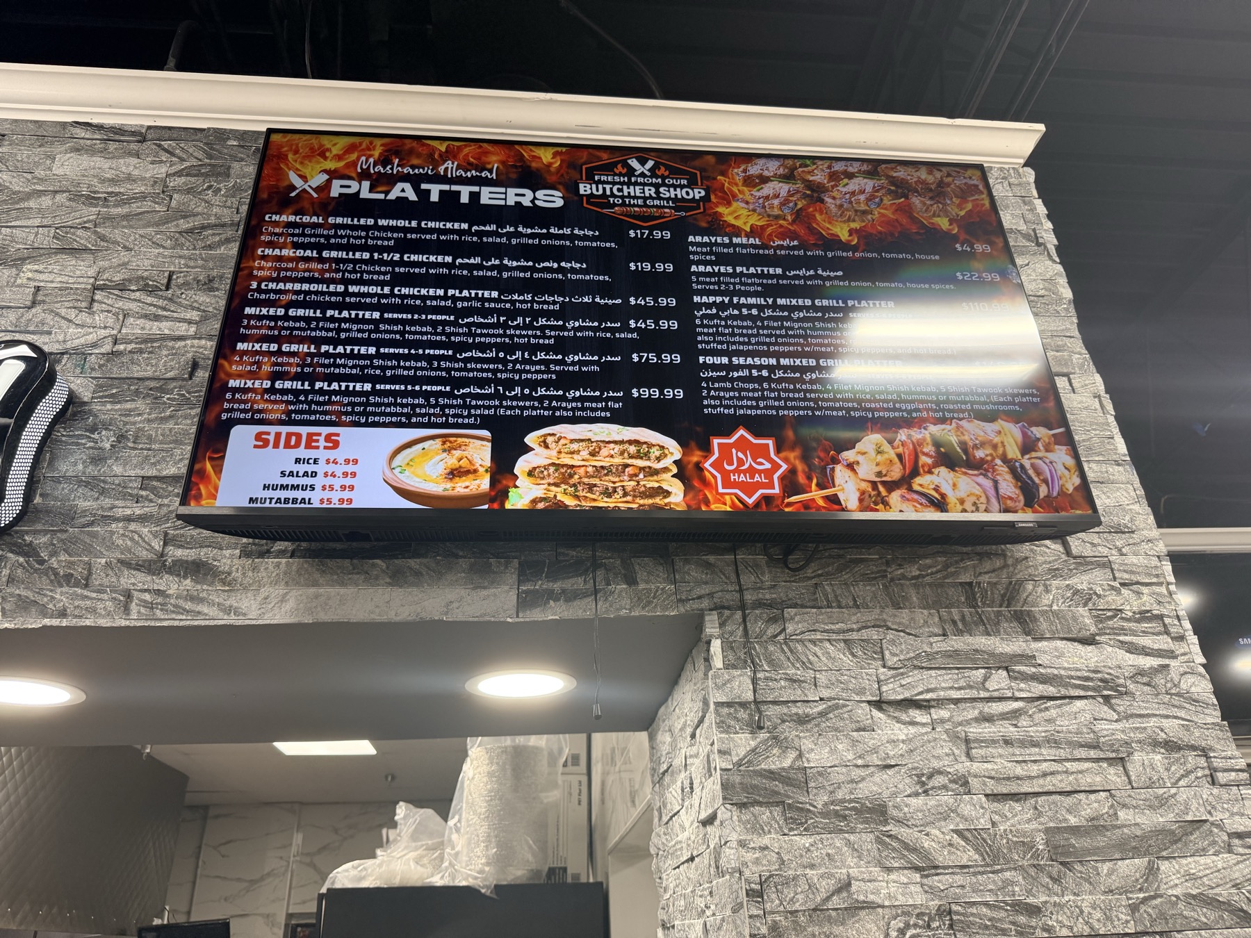 The hand-written platters menu board at Mashawi Alamal